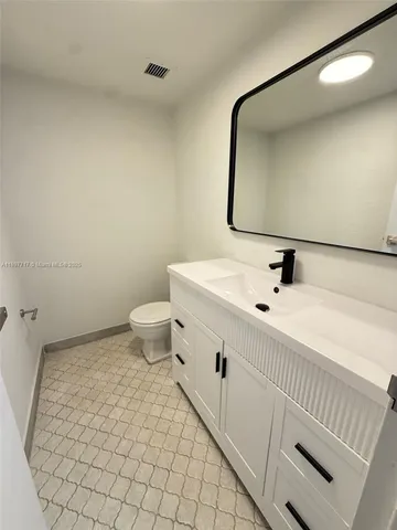 a bathroom with a sink mirror and toilet