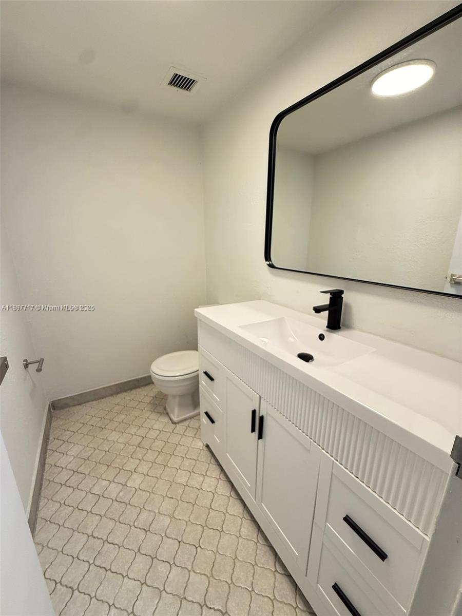 13499 Biscayne Boulevard, Unit 811 North Miami, FL 33181 - Photo 4 of 20 a bathroom with a sink mirror and toilet