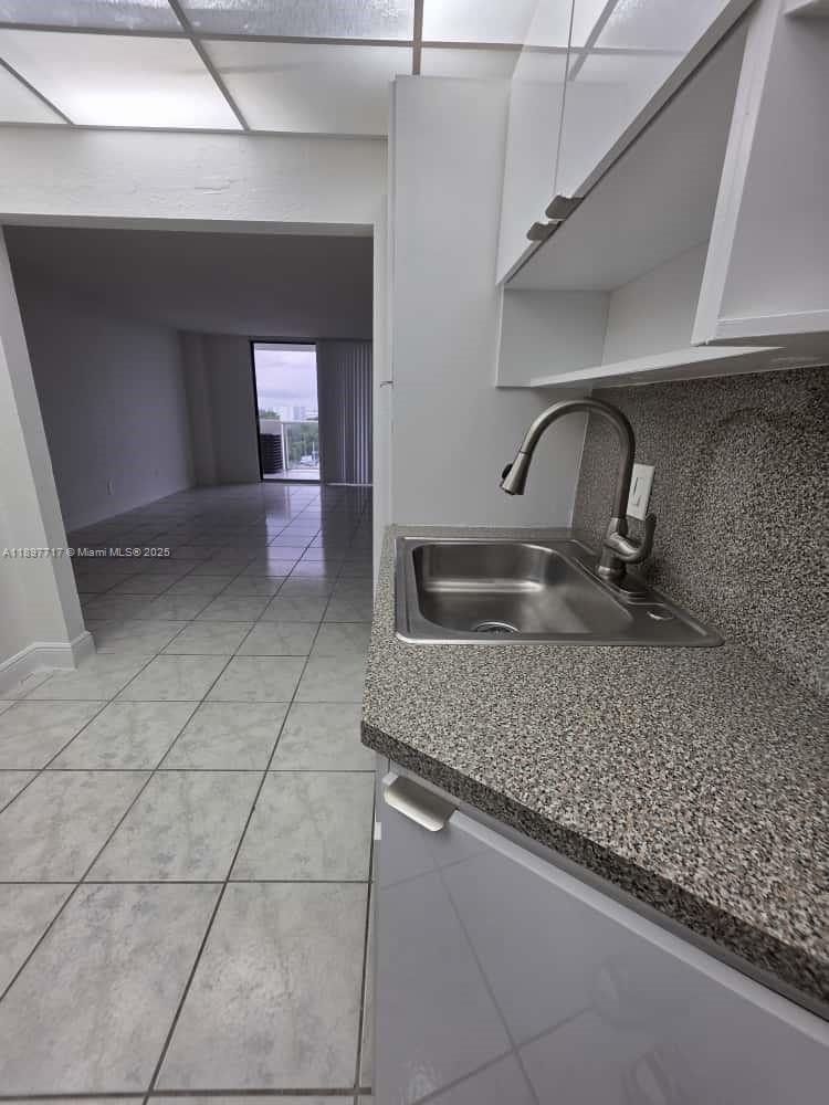 13499 Biscayne Boulevard, Unit 811 North Miami, FL 33181 - Photo 8 of 20 a kitchen with a sink a stove and cabinets