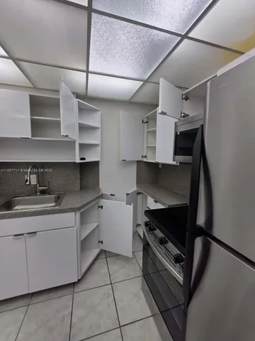 a kitchen with stainless steel appliances a sink dishwasher stove and cabinets