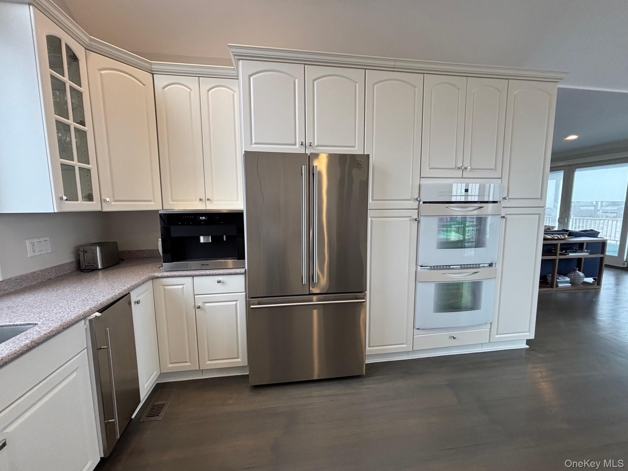 939 Dune Road West Hampton Dunes, NY 11978 - Photo 11 of 25 a kitchen with stainless steel appliances white cabinets and a refrigerator