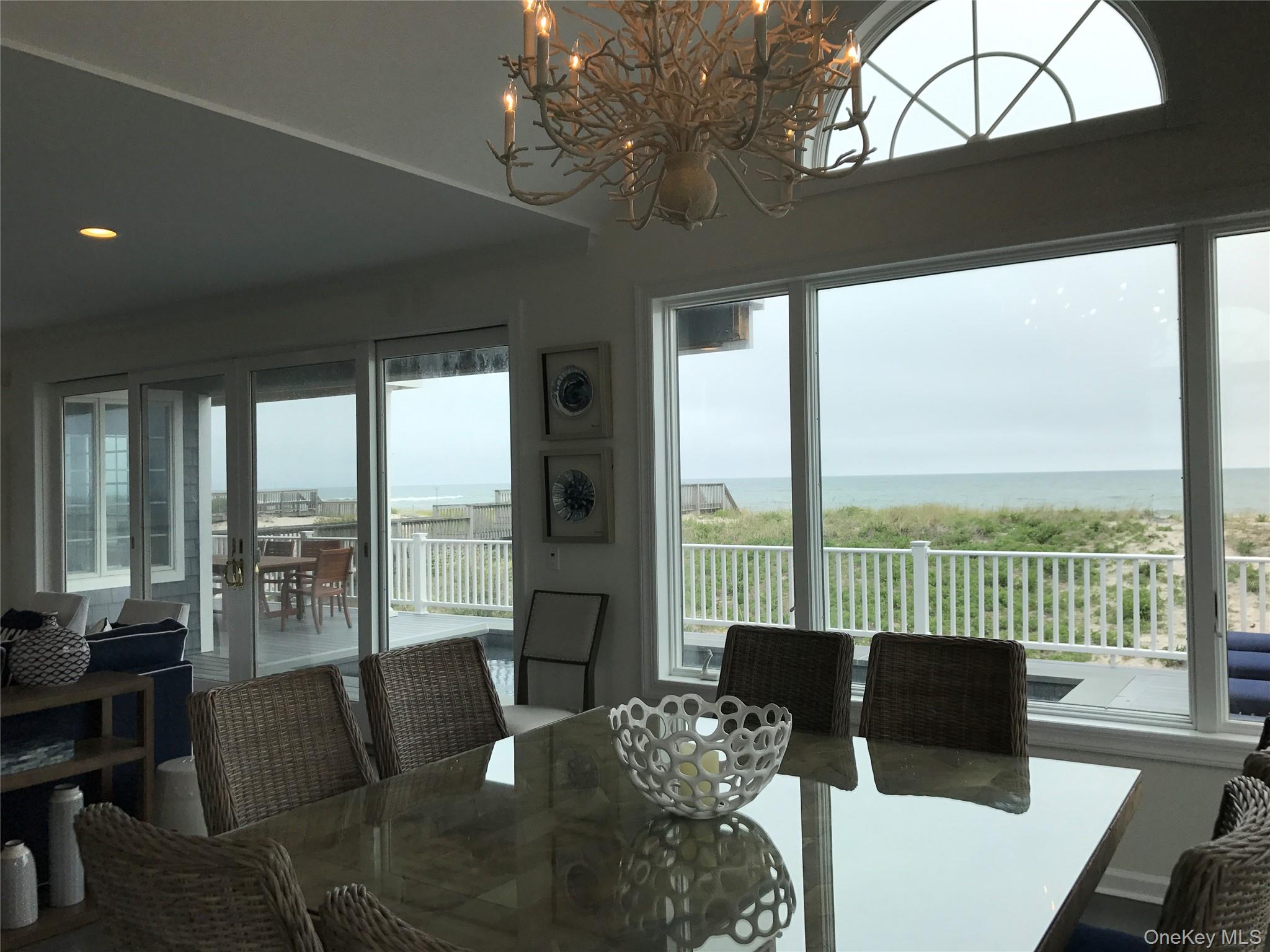 939 Dune Road West Hampton Dunes, NY 11978 - Photo 13 of 25 a living room with furniture floor to ceiling window and a table