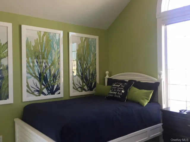 a bedroom with a bed and a painting on the wall