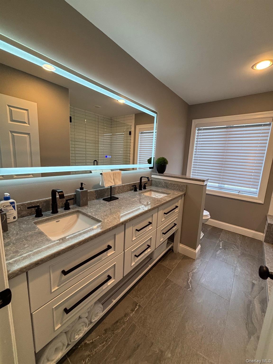 939 Dune Road West Hampton Dunes, NY 11978 - Photo 21 of 25 a spacious bathroom with double vanity and a mirror