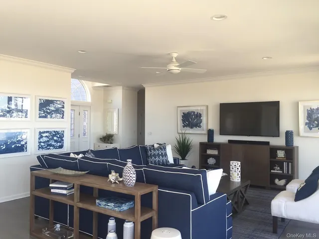 a living room with furniture a flat screen tv and kitchen view