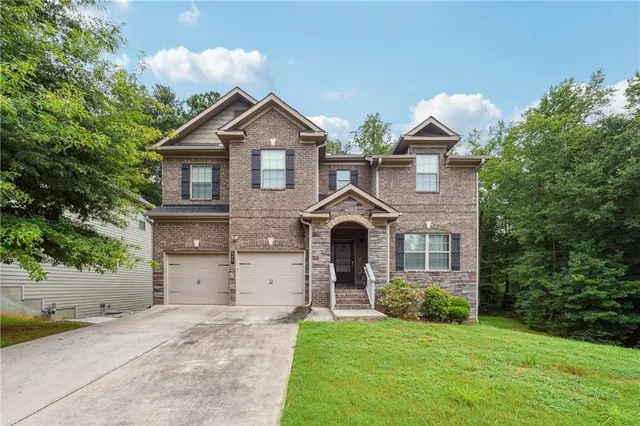a front view of a house with a yard and garage