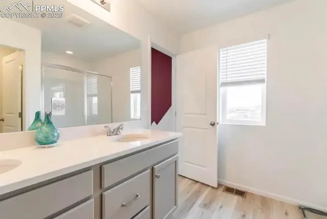 a bathroom with a granite countertop sink and a mirror