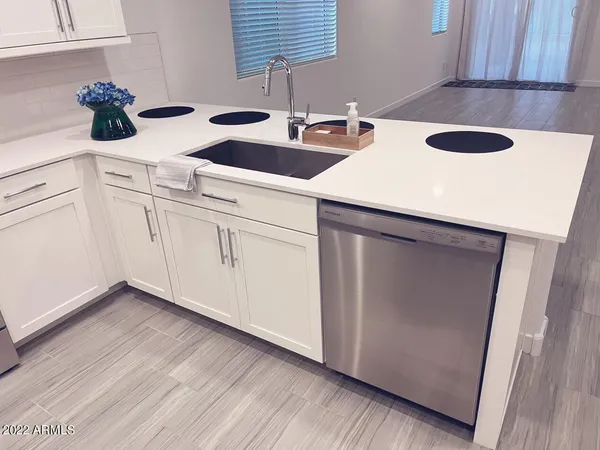 a kitchen with a sink a counter space and cabinets