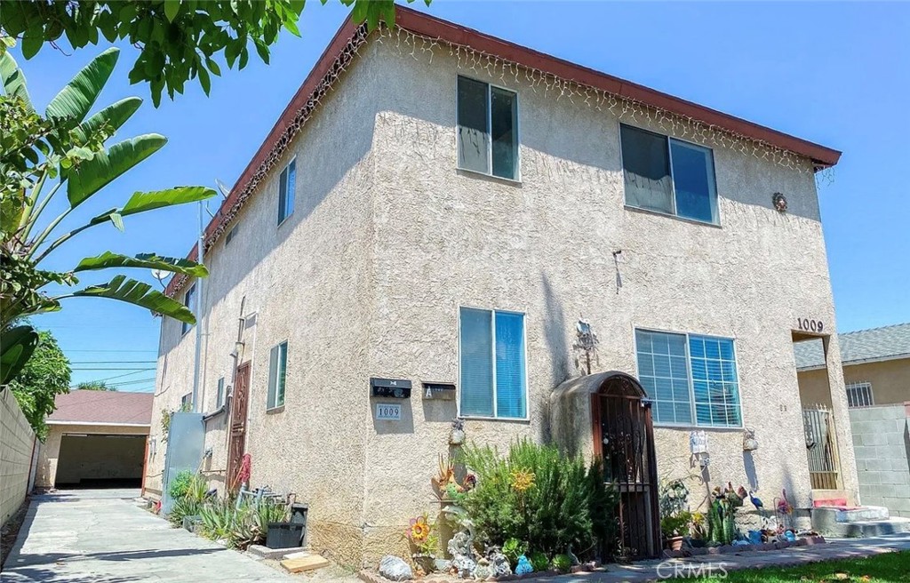 1009 East Stockton Street Compton, CA 90221 - Photo 1 of 14 a front view of a house with a garden