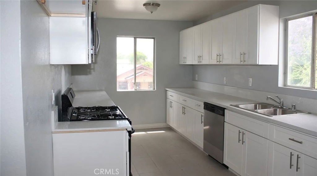1009 East Stockton Street Compton, CA 90221 - Photo 2 of 14 a kitchen with cabinets appliances a sink and a window