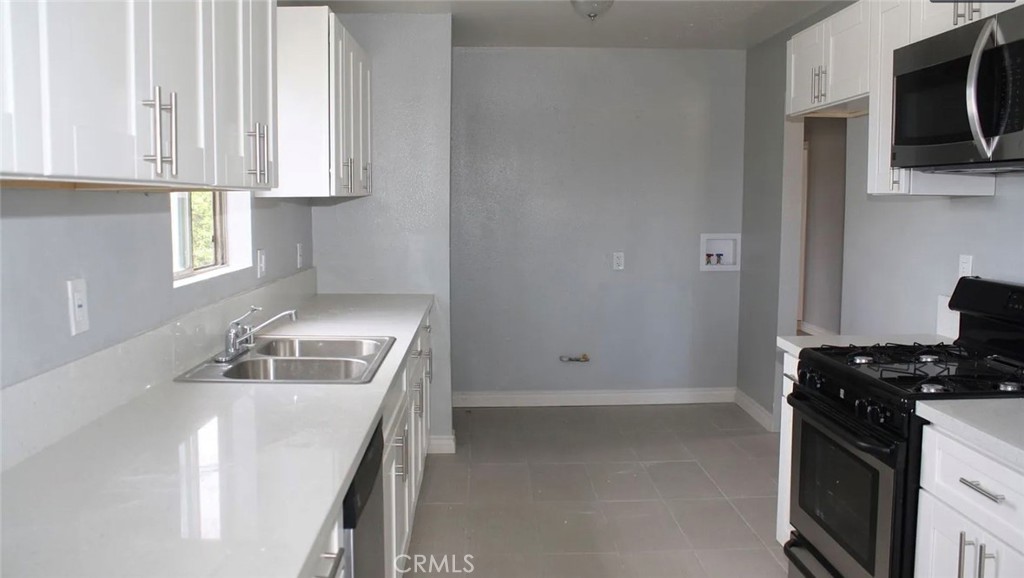 1009 East Stockton Street Compton, CA 90221 - Photo 3 of 14 a kitchen with a sink stove and microwave