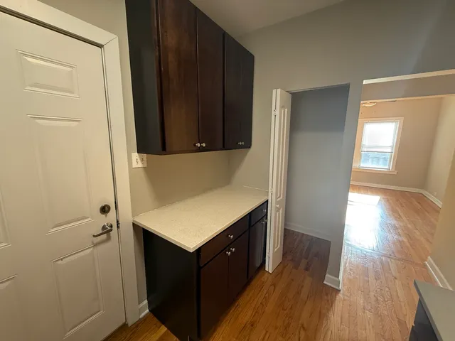 a kitchen with a wooden floor and cabinets