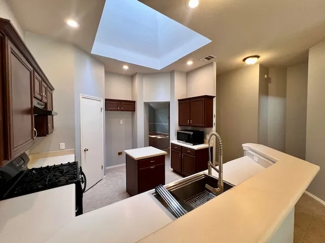 a kitchen with a sink a refrigerator and cabinets