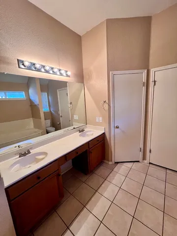 a spacious bathroom with a tub sink and mirror