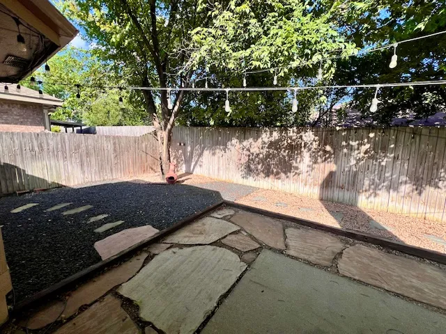 a view of a yard with wooden fence and a tree