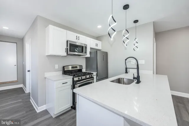 a kitchen with stainless steel appliances granite countertop a sink a stove and a refrigerator