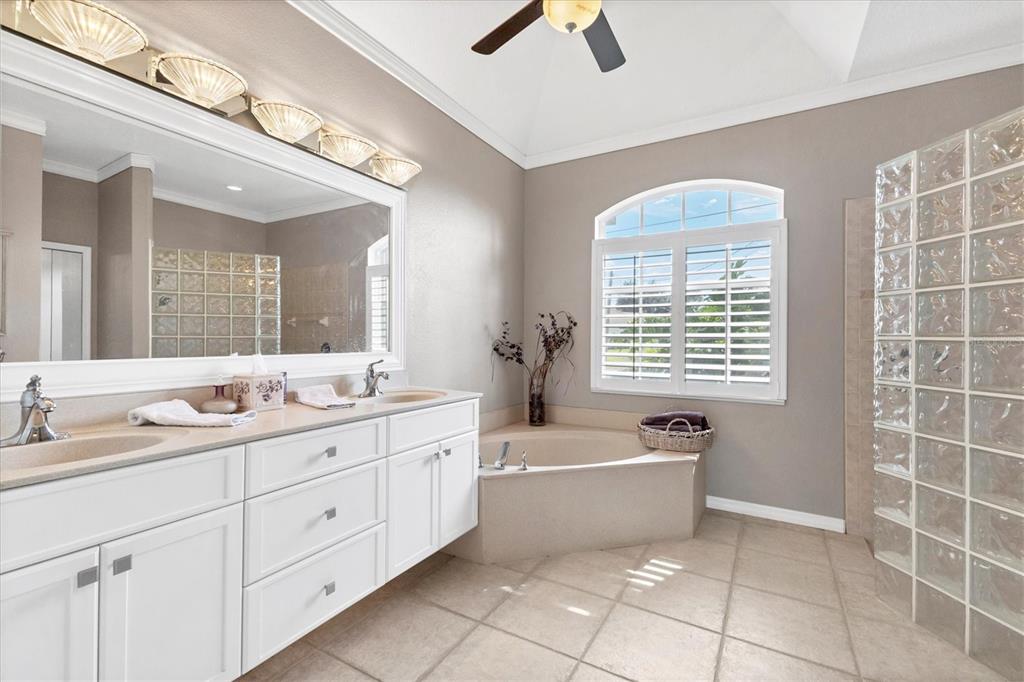 42 Medalist Lane Rotonda West, FL 33947 - Photo 29 of 61 a spacious bathroom with a double vanity sink a mirror and a bathtub