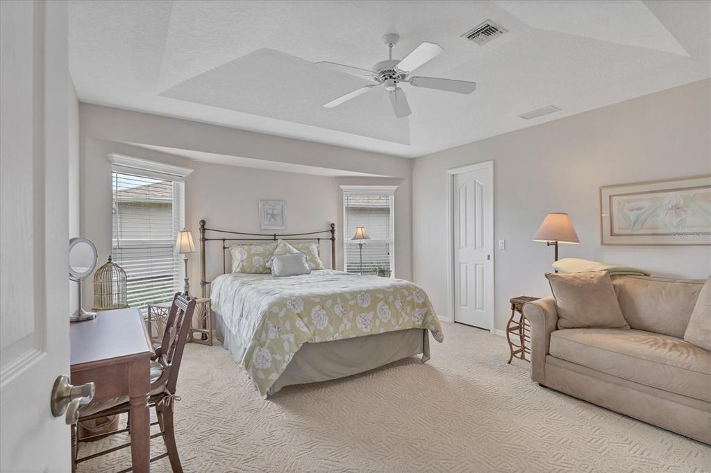 42 Medalist Lane Rotonda West, FL 33947 - Photo 31 of 61 a spacious bedroom with a bed a couch and chandelier