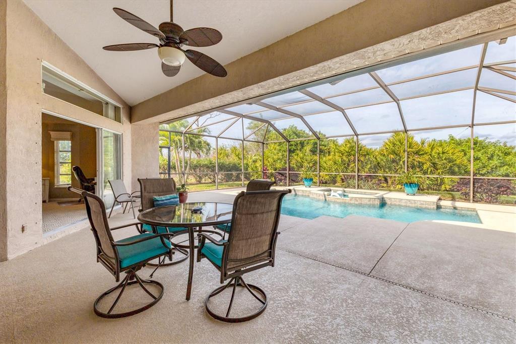42 Medalist Lane Rotonda West, FL 33947 - Photo 36 of 61 a view of a patio with table and chairs under an umbrella