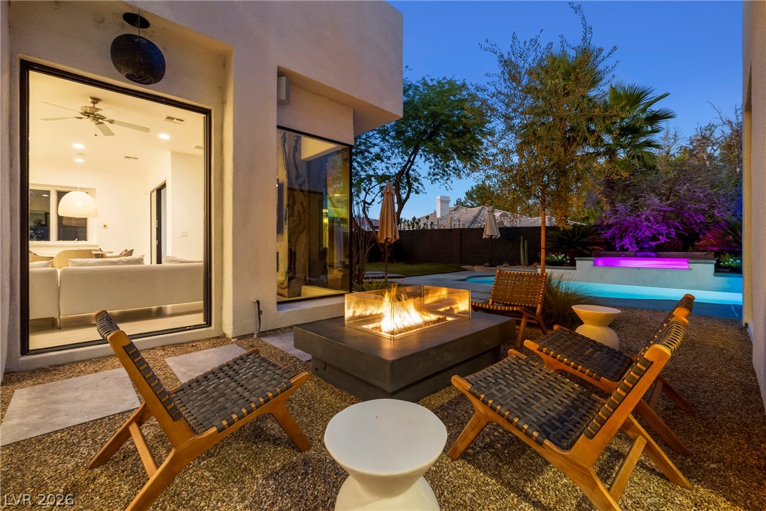 2000 Grouse Street Las Vegas, NV 89134 - Photo 64 of 89 An inviting outdoor retreat, complete with a fire pit and illuminated pool, offers tranquil evening relaxation.