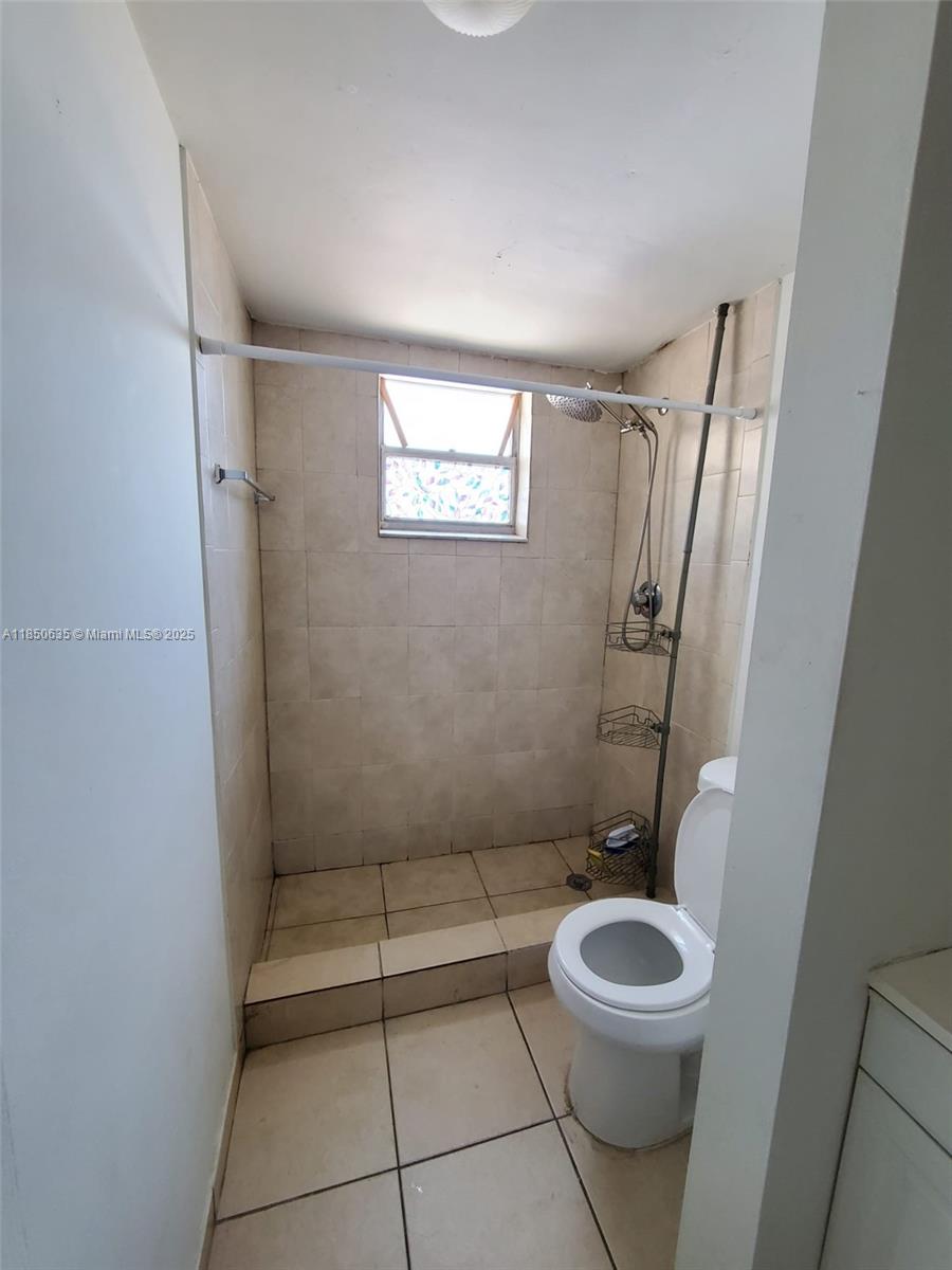 1100 Northeast 1st Court, Unit 106 Hallandale Beach, FL 33009 - Photo 2 of 16 a bathroom with a toilet a sink and shower