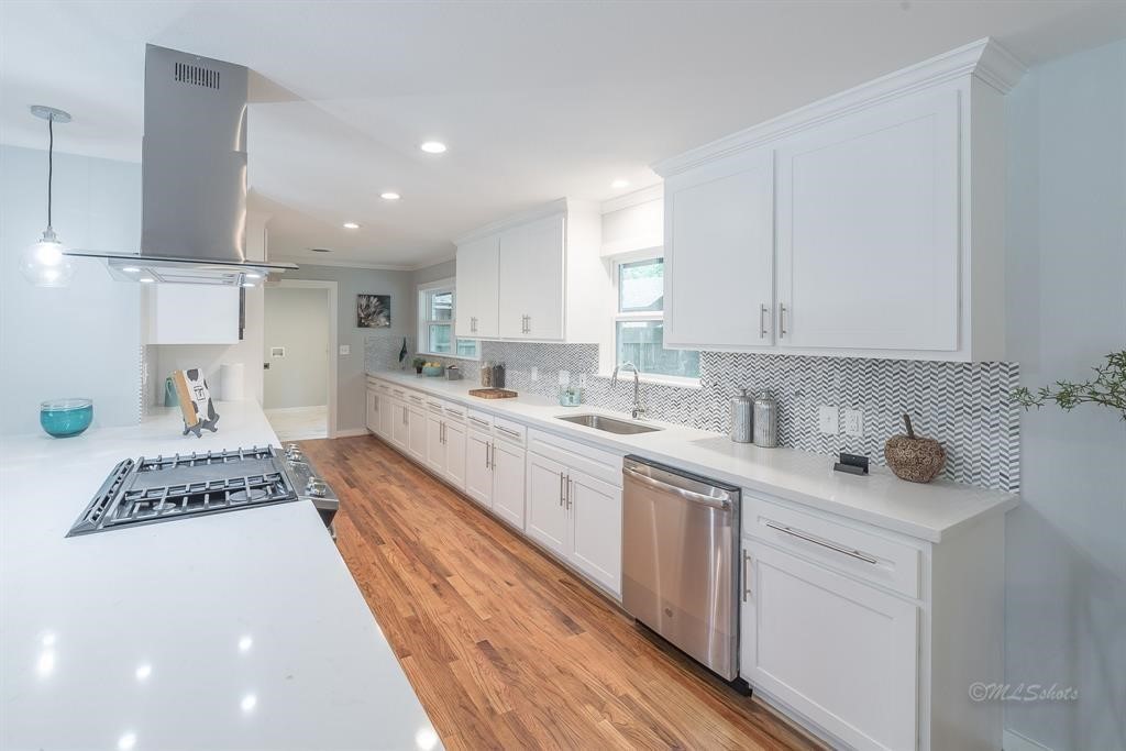 10058 Larston Street Houston, TX 77055 - Photo 10 of 18 a large white kitchen with stainless steel appliances granite countertop a stove a sink a refrigerator and white cabinets