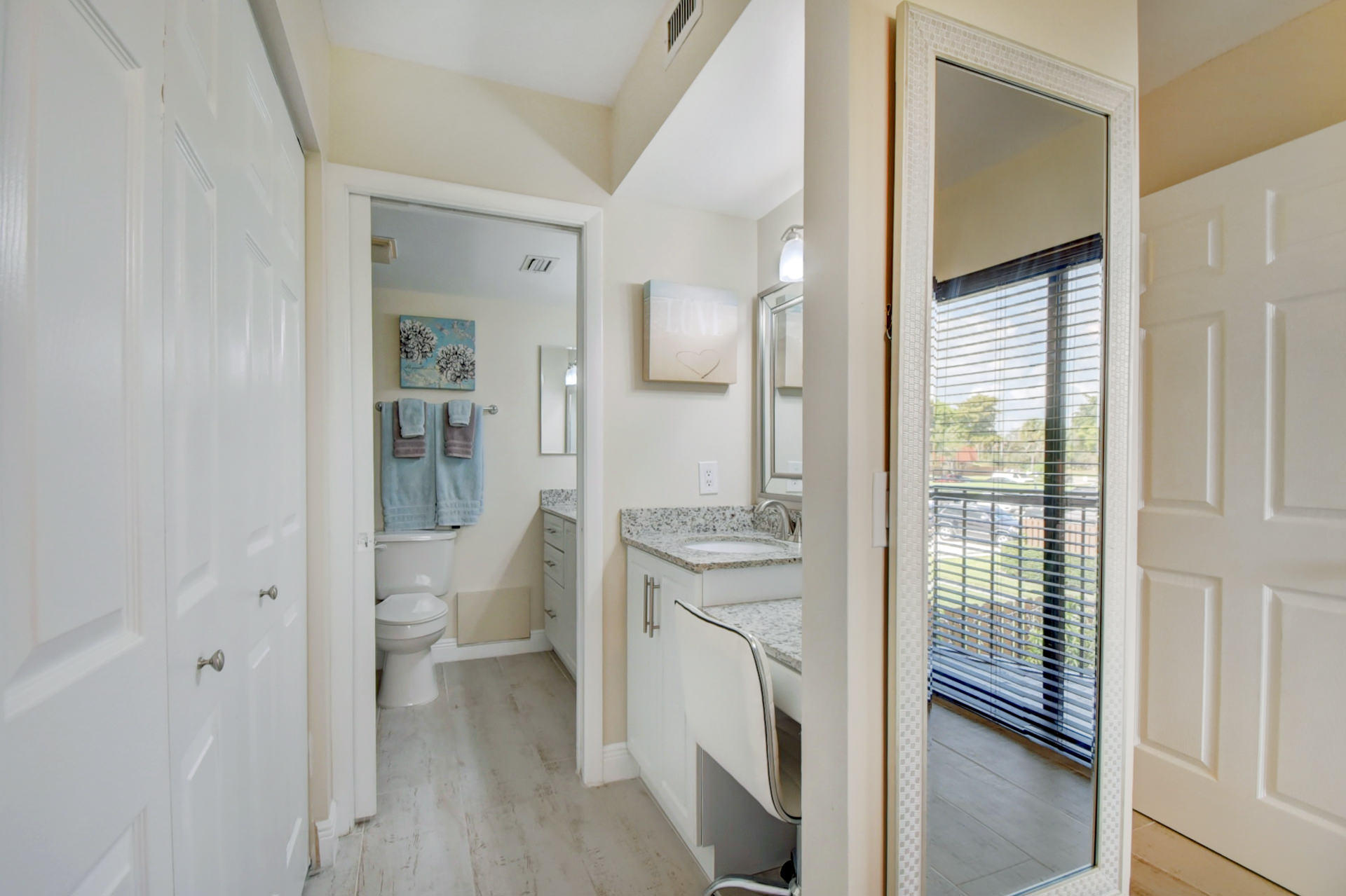 23048 Oxford Place, Unit A Boca Raton, FL 33433 - Photo 11 of 18 a spacious bathroom with a toilet a sink and a mirror