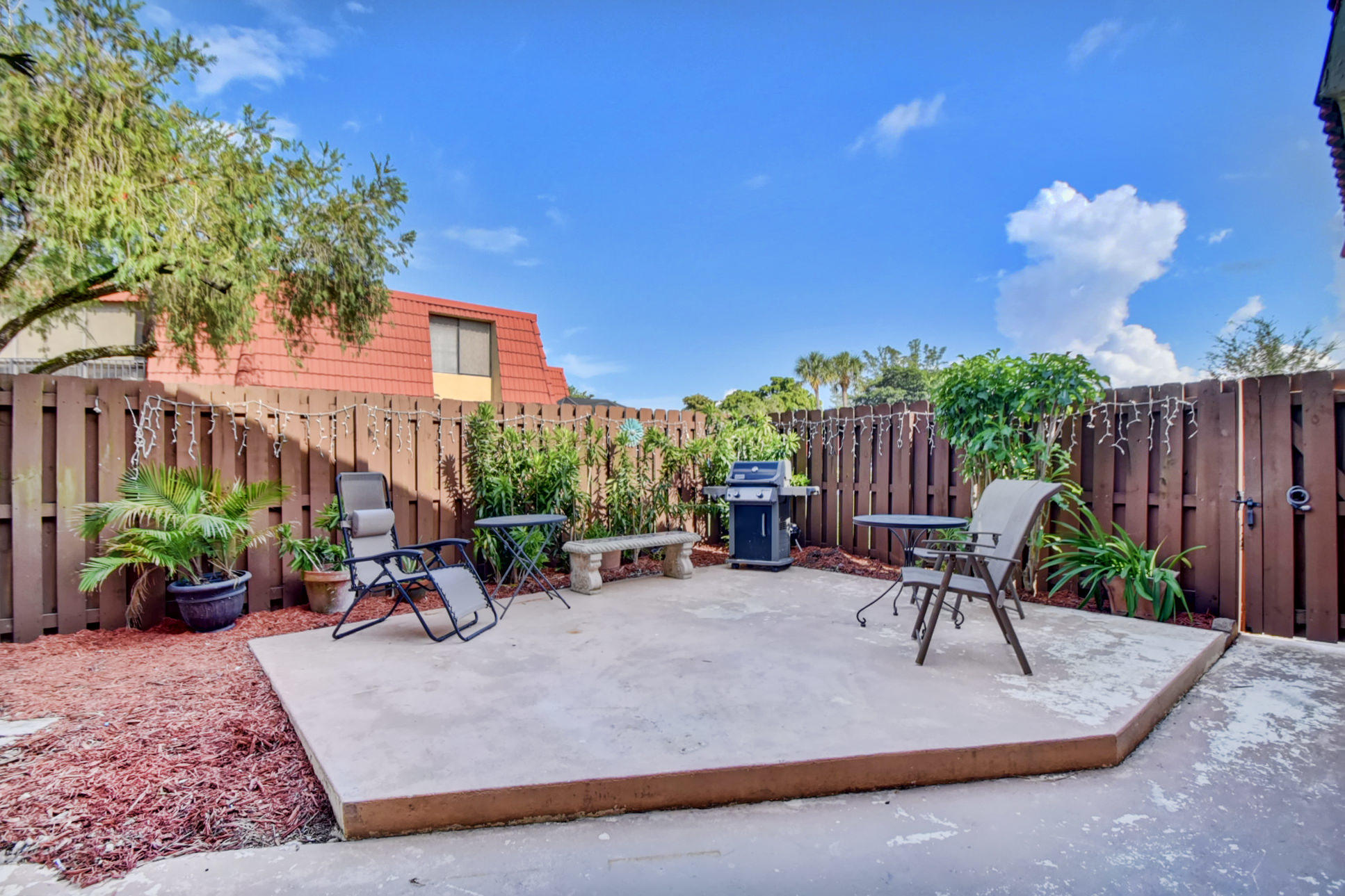 23048 Oxford Place, Unit A Boca Raton, FL 33433 - Photo 16 of 18 a view of a patio with a table and chairs