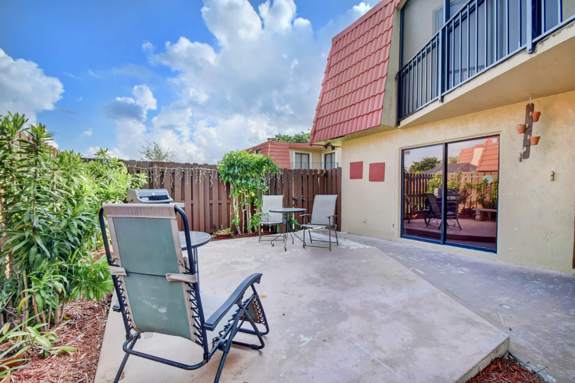 23048 Oxford Place, Unit A Boca Raton, FL 33433 - Photo 17 of 18 a view of a patio with a table and chairs