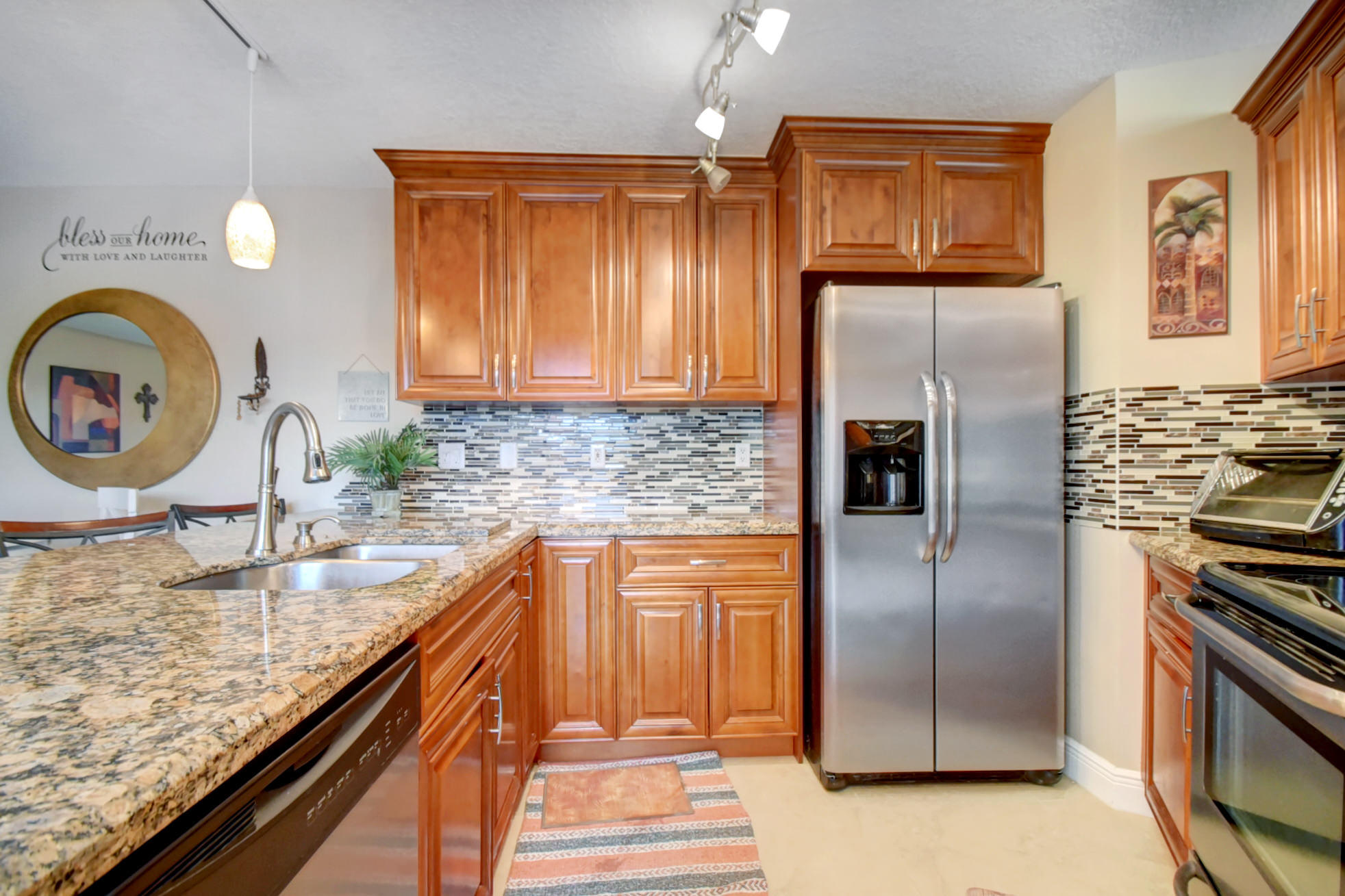 23048 Oxford Place, Unit A Boca Raton, FL 33433 - Photo 5 of 18 a kitchen with granite countertop stainless steel appliances and wooden cabinets