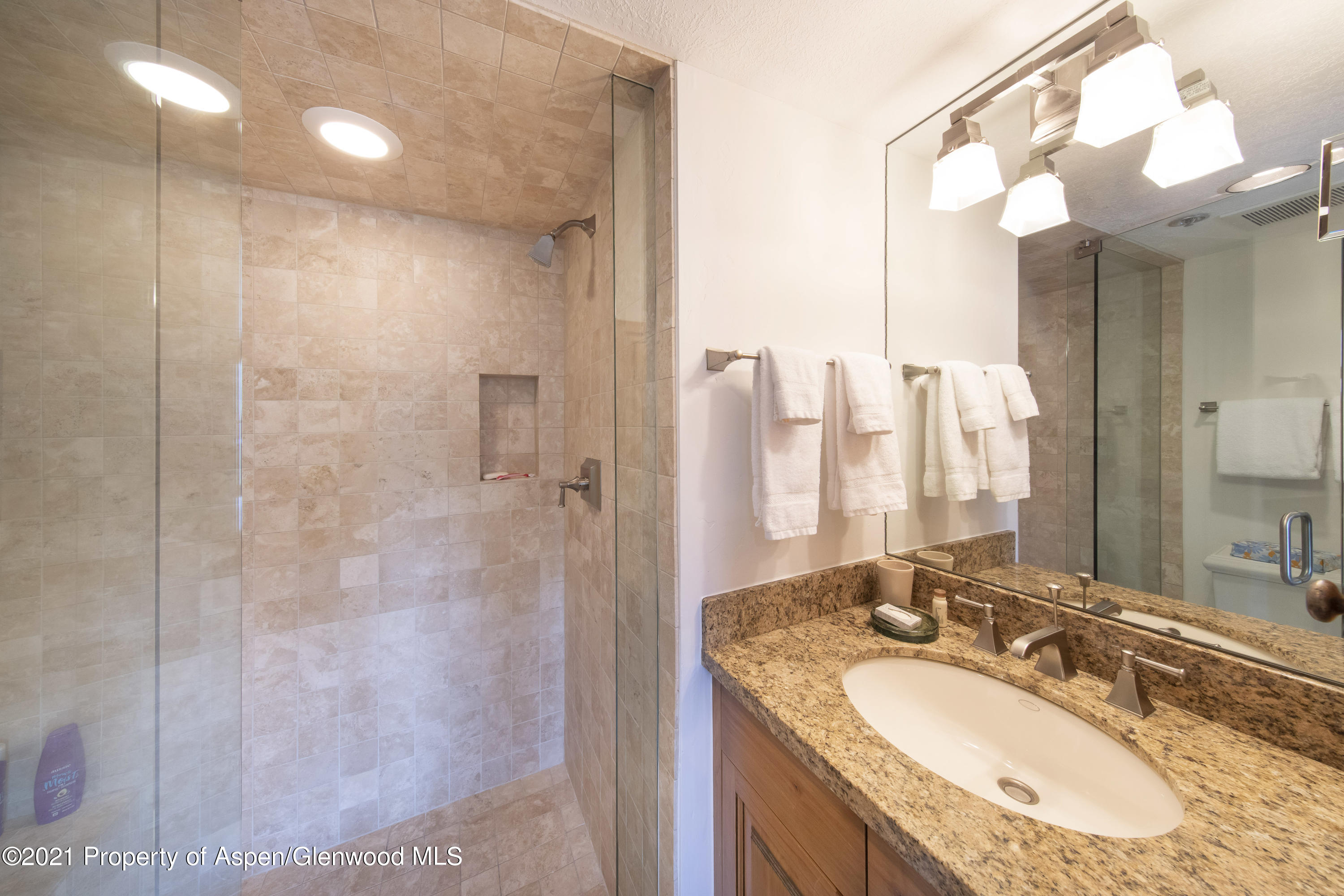 425 Wood Run Road, Unit 36 Snowmass Village, CO 81615 - Photo 13 of 23 a bathroom with a granite countertop sink a mirror and a shower