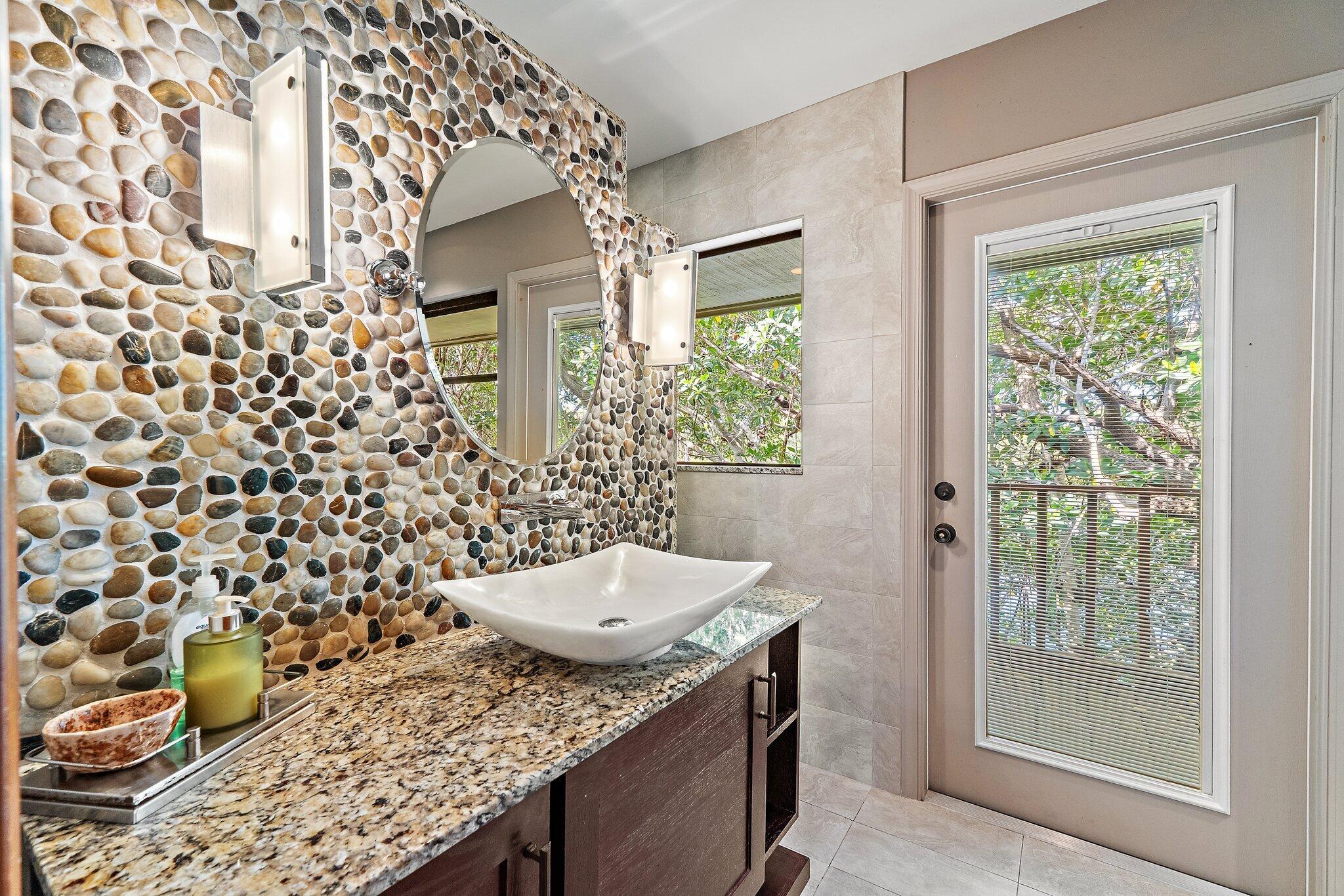 702 Warren Drive Jupiter, FL 33458 - Photo 46 of 76 a bathroom with a granite countertop sink and a mirror