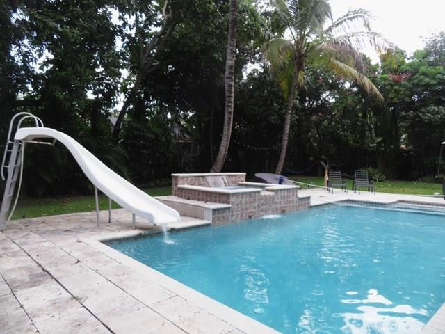540 Bay Point Road Miami, FL 33137 - Photo 3 of 42 a view of swimming pool with a garden and trees
