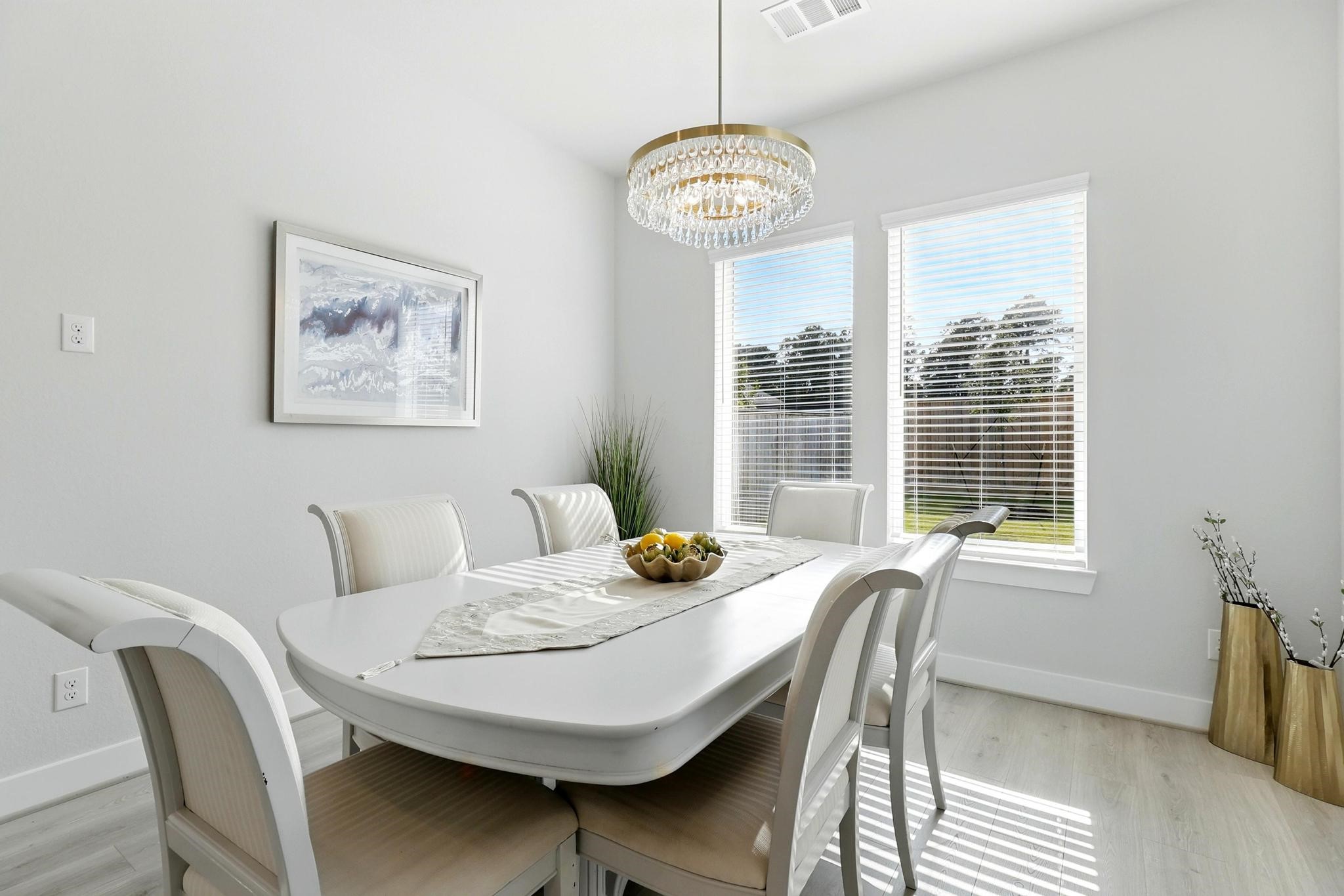 26923 Arethusa Court Spring, TX 77389 - Photo 22 of 44 Bright dining area featuring a modern chandelier, stylish will allows to fit a table with seating for six or eight and large windows offering ample natural light. Elegant decor and a serene atmosphere make it perfect for gatherings.