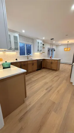 a living room with stainless steel appliances kitchen island granite countertop a sink and cabinets