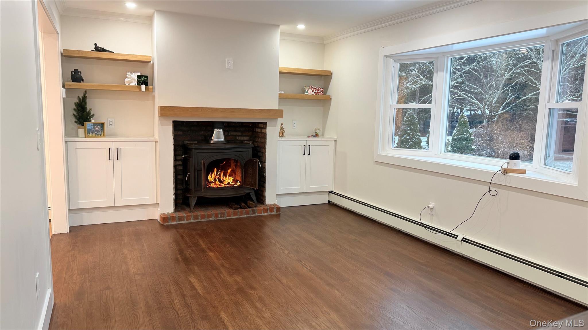 94 Sally Lane Ridge, NY 11961 - Photo 7 of 17 a view of an empty room with wooden floor fireplace and a window