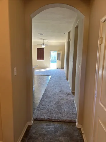 a view of a hallway with wooden floor and cabinet