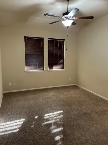 a view of a livingroom with a ceiling fan and window