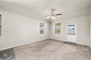a view of a big room with chandelier fan and windows
