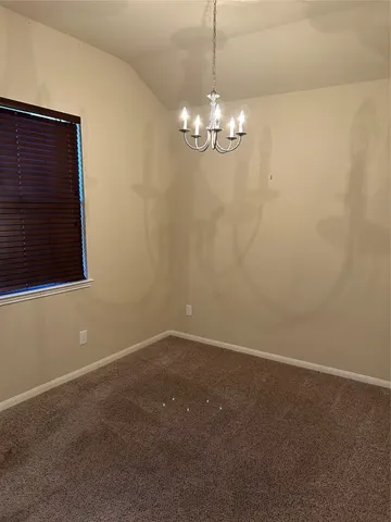 a view of empty room with chandelier