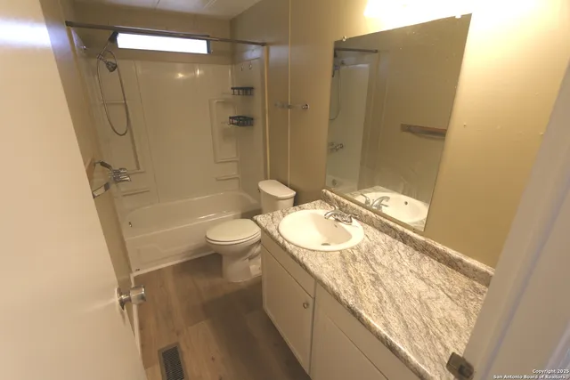 a bathroom with a granite countertop sink toilet and shower