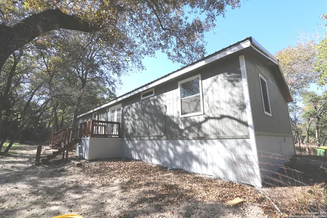 a view of a yard with wooden fence