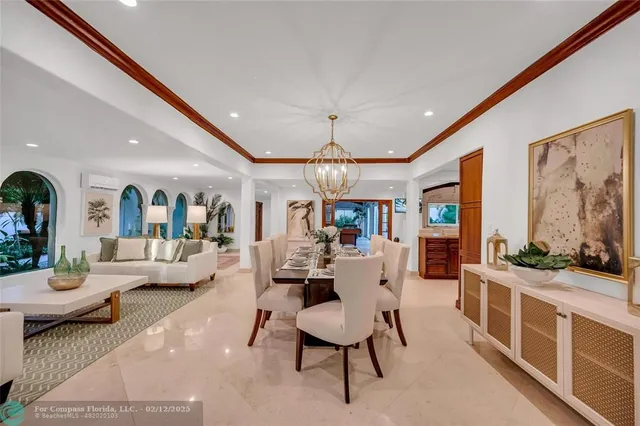 a living room with furniture a large window and potted plants