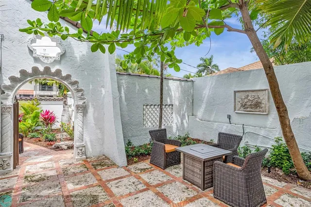 a view of a patio with table and chairs potted plants