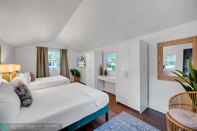 a bedroom with a bed and a large window with balcony view