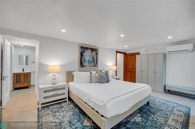 a bedroom with a large bed a chandelier and a window