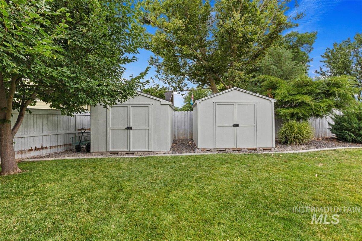 5184 North Greyloch Way Boise, ID 83704 - Photo 23 of 32 Expansive backyard featuring a large patio, manicured lawn, stone fire pit, and mature trees