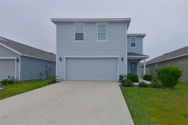 a front view of a house with a yard and garage