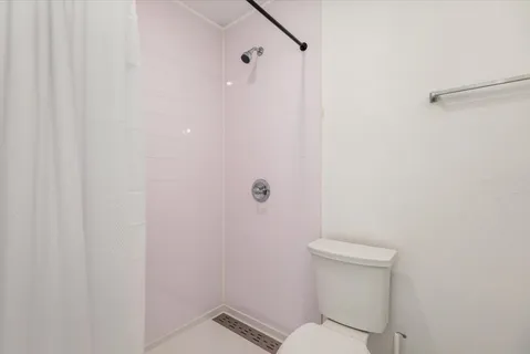 a white toilet sitting next to a shower