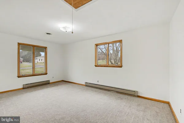 an empty room with a ceiling fan and a window